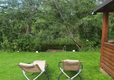 two chairs sitting in the grass in a yard at Kabakėlio slėnis in Kabakelis
