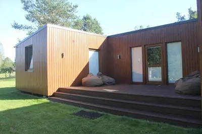 a small wooden house with two large pillows on a deck at Kabakėlio slėnis in Kabakelis