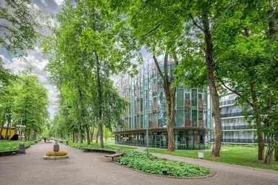 a park with benches and trees and a building at Sun Sonata Apartments 3 in Druskininkai