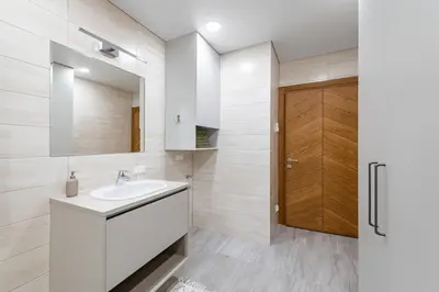a white bathroom with a sink and a mirror at Sun Sonata Apartments 3 in Druskininkai