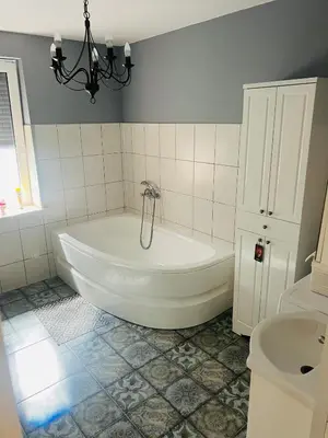 a bathroom with a white tub and a sink at Už Karvelius - Sodyba Biržų mieste in Biržai