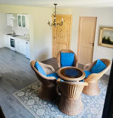 a living room with wicker chairs and a table at Už Karvelius - Sodyba Biržų mieste in Biržai