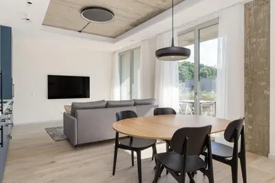 a living room with a table and chairs and a couch at Light- Filled Flat with Balcony in a Heart of Kaunas in Kaunas