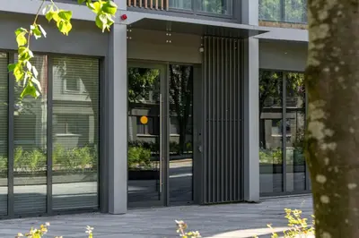 a facade of a building with revolving glass doors at Light- Filled Flat with Balcony in a Heart of Kaunas in Kaunas