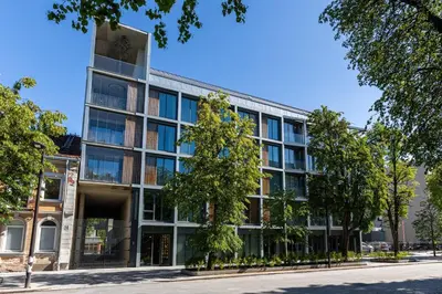 an office building with trees in front of it at Light- Filled Flat with Balcony in a Heart of Kaunas in Kaunas