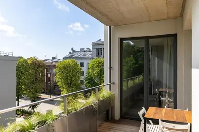 a balcony with a table and a view of a city at Light- Filled Flat with Balcony in a Heart of Kaunas in Kaunas