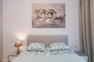 a bedroom with a bed with a picture of four horses at Sun Sonata Apartments 1 in Druskininkai