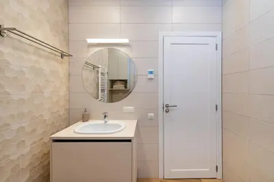 a white bathroom with a sink and a mirror at Sun Sonata Apartments 1 in Druskininkai