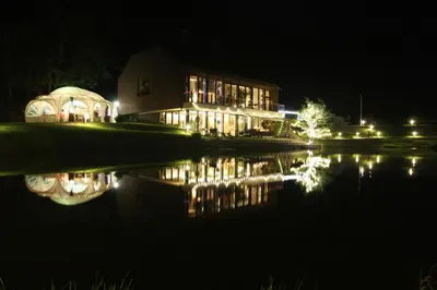a house at night with a reflection in the water at Kernavės Pajauta in Kernavė