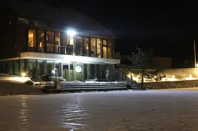 a building at night with snow in front of it at Kernavės Pajauta in Kernavė