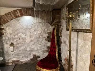 a red chair in a room with a stone wall at Apartment Host 4 in Kaunas