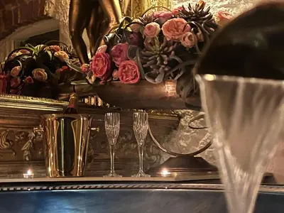 a vase of flowers on a table with two glasses at Host 1 apartment in Kaunas
