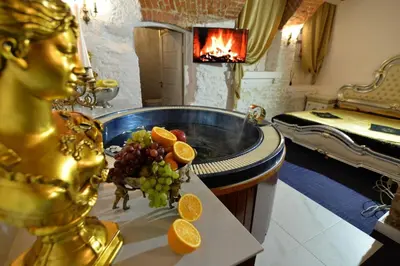 a bathroom with a tub with grapes and oranges on a table at Host 1 apartment in Kaunas