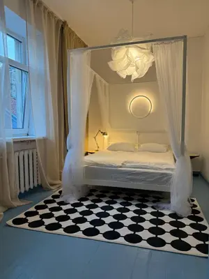 a bedroom with a canopy bed with a checkered floor at Uzupio4 Old Town House in Vilnius