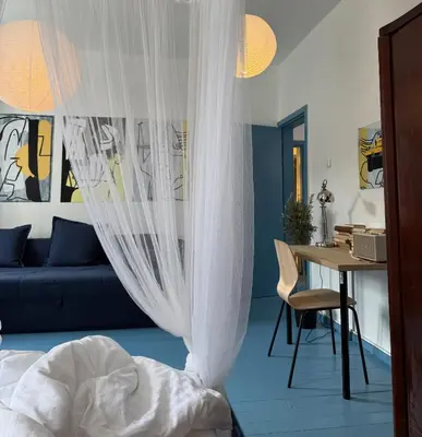 a bedroom with a bed and a desk and a table at Uzupio4 Old Town House in Vilnius