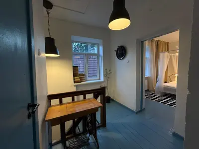 a room with a wooden table and a window at Uzupio4 Old Town House in Vilnius