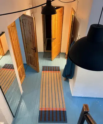 a view of a hallway with doors and a lamp at Uzupio4 Old Town House in Vilnius