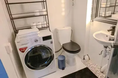 a small bathroom with a washing machine and a sink at Uzupio4 Old Town House in Vilnius