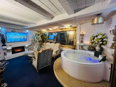 a large bathroom with a large tub and a living room at Apartment Host 2 in Kaunas