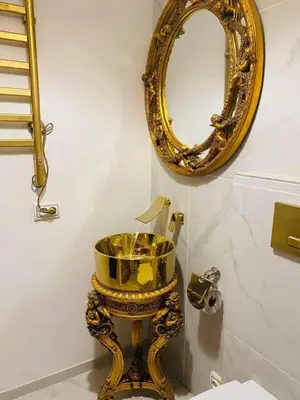 a bathroom with a gold mirror and a toilet at Apartment Host 2 in Kaunas