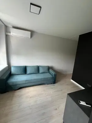 a living room with a blue couch in a room at Apartamentai 1 in Raseiniai