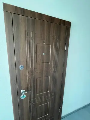 a wooden door with a handle in a room at Apartamentai 1 in Raseiniai