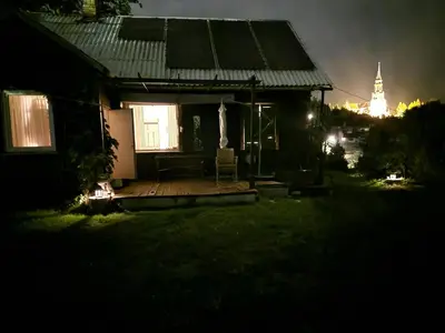 a house with a deck in the yard at night at Hilltop view - 2 bedroom house with garden bbq - private parking - 12min to Uzupis anytime in Vilnius