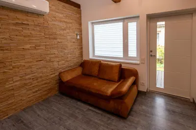 a leather chair in a room with a brick wall at Marvelės 30 Lofts in Kaunas