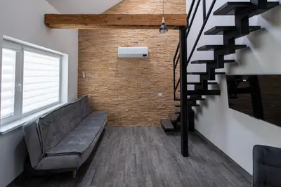 a living room with a couch and a staircase at Marvelės 30 Lofts in Kaunas