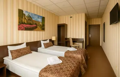 a hotel room with two beds and a table at Naujamiescio Studio 305 in Vilnius