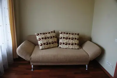 a couch in a room with two pillows on it at Lyra Apartments in Druskininkai
