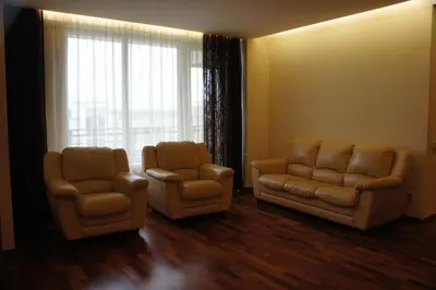 a living room with two chairs and a couch and a window at Lyra Apartments in Druskininkai