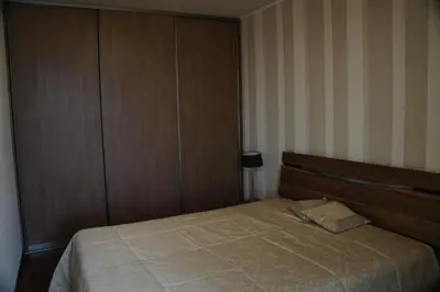a bedroom with a bed with a wooden headboard at Lyra Apartments in Druskininkai