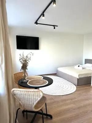 a bedroom with a bed and a table and chairs at Dvaro central studio in Šiauliai