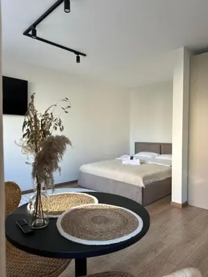 a living room with a table and a bed at Dvaro central studio in Šiauliai