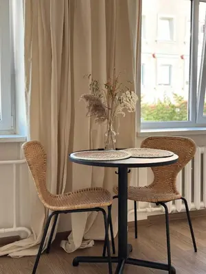a table and two chairs with a vase on it at Dvaro central studio in Šiauliai