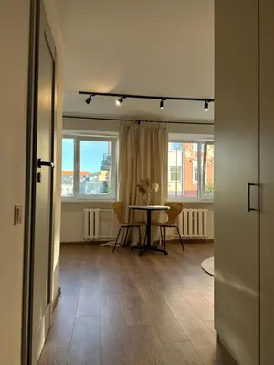 a dining room with a table and two windows at Dvaro central studio in Šiauliai