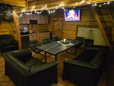 a dining room with a table and chairs and lights at Sodyba Prie Maluno in Salakas