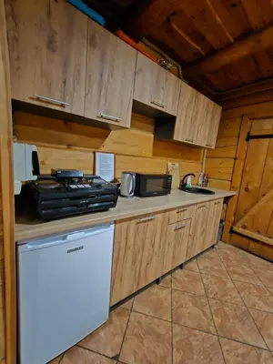 a kitchen with wooden cabinets and a white refrigerator at Sodyba Prie Maluno in Salakas