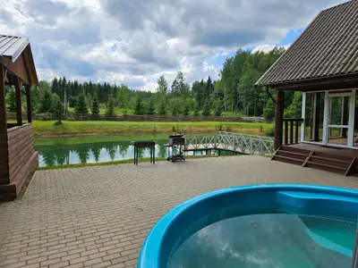a swimming pool on a patio next to a lake at Sodyba Prie Maluno in Salakas