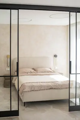 a bedroom with a bed with glass doors at Stylish apartment next to the center in Vilnius