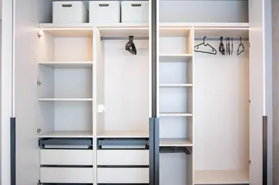 a walk in closet with white cabinets and shelves at Stylish apartment next to the center in Vilnius
