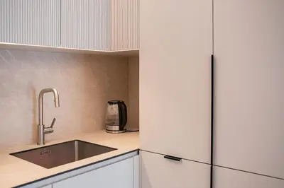 a kitchen with a sink and a refrigerator at Stylish apartment next to the center in Vilnius