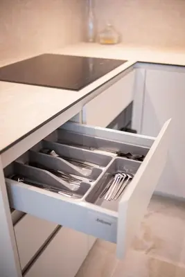 a white kitchen drawer with utensils in it at Stylish apartment next to the center in Vilnius