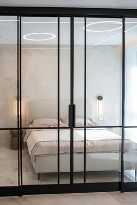 a bedroom with a bed with glass walls at Stylish apartment next to the center in Vilnius