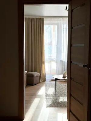 an open door to a living room with a table at Lake Town apartments in Zarasai