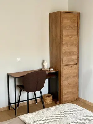 a desk with a chair next to a closet at Lake Town apartments in Zarasai