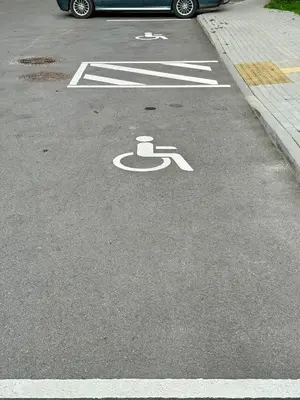 a handicapped symbol on the road in a parking lot at Lake Town apartments in Zarasai