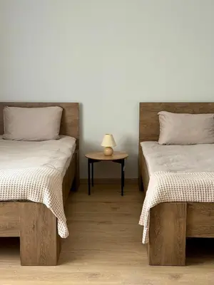 a bedroom with two beds and a table with a lamp at Lake Town apartments in Zarasai