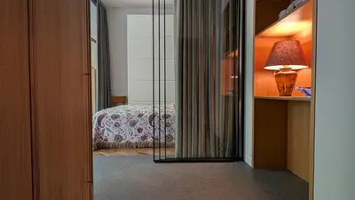 a room with a bedroom with a bed and a lamp at Avenue Apartments in Kaunas